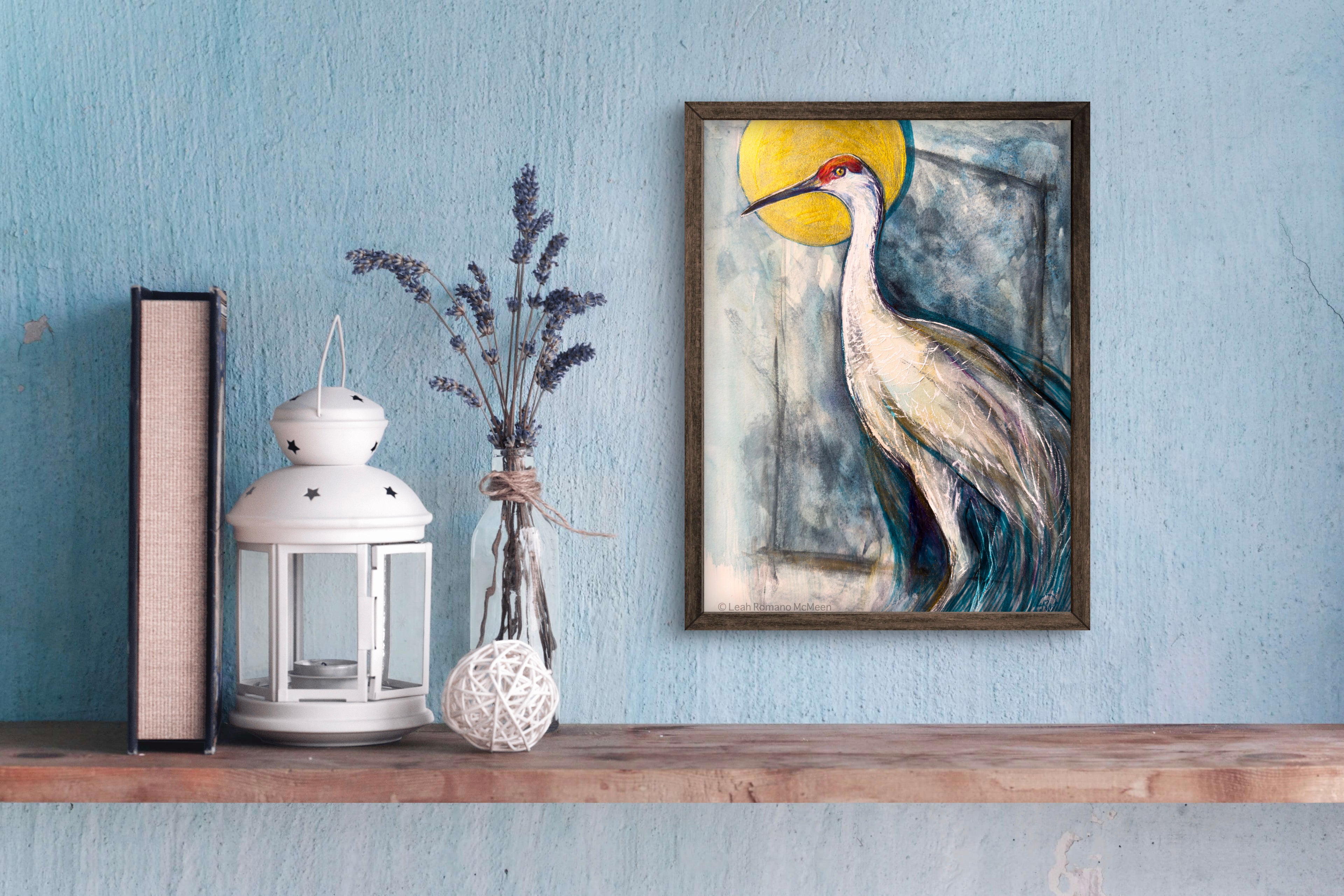 Framed artwork of a bird on a wooden shelf against a blue wall