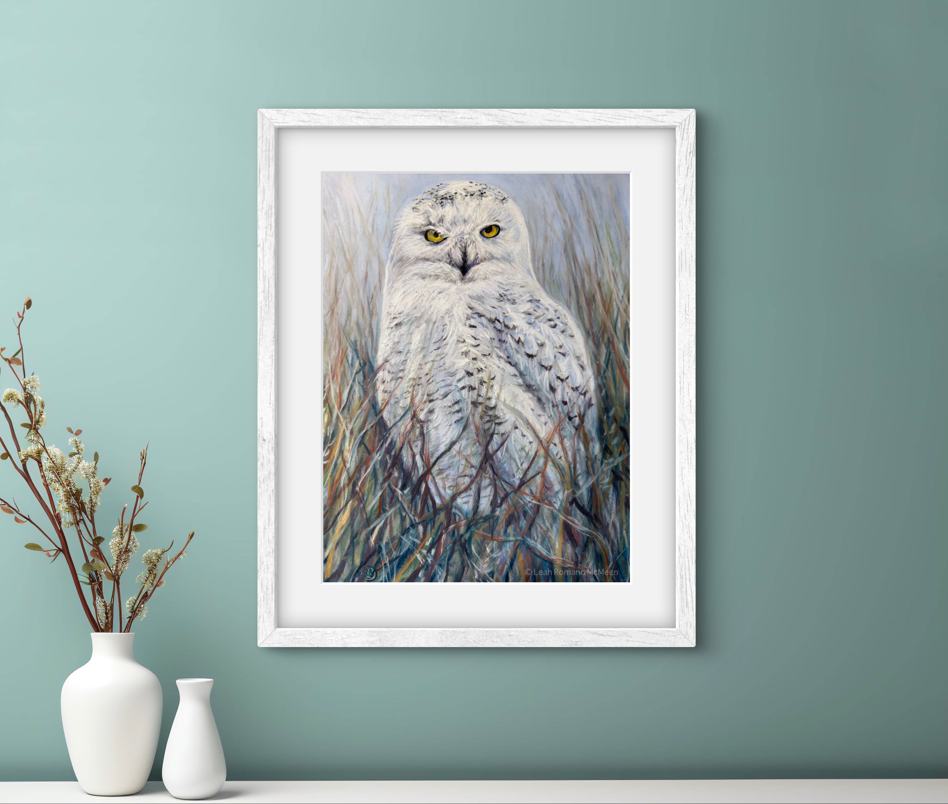 Framed artwork of an owl on a wall with decorative vases below.