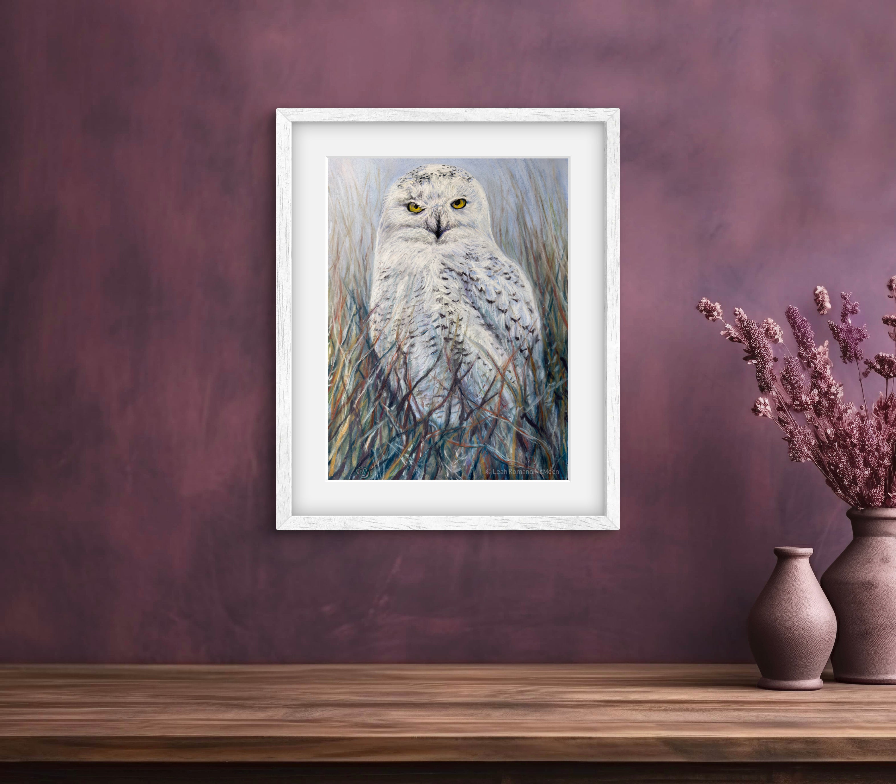 Framed artwork of an owl on a wall with decorative vases below.