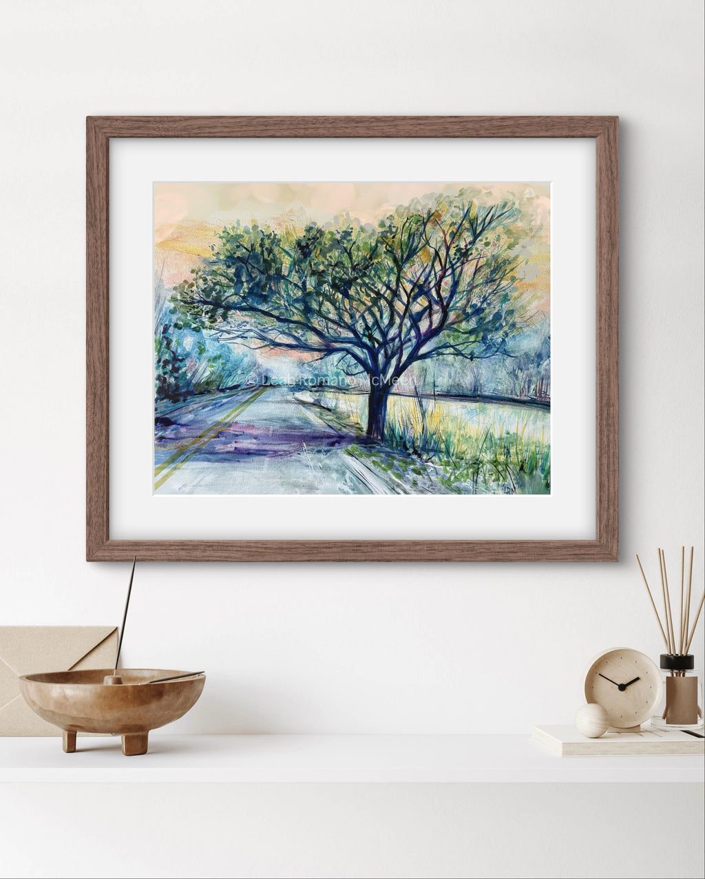 Framed painting of a tree on a white wall.