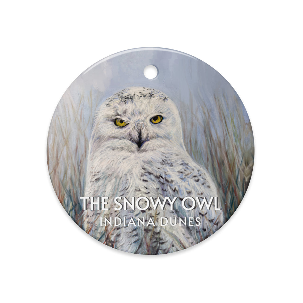 Round ornament with a snowy owl and text 'The Snowy Owl Indiana Dunes' on a white background